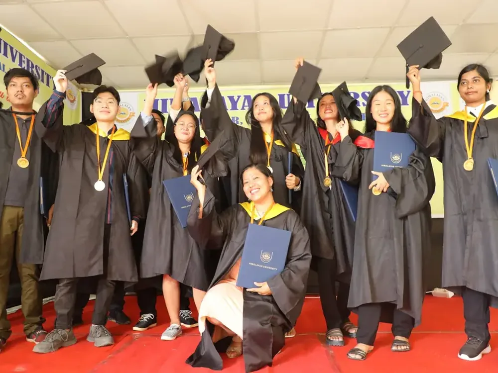 Students in graduation caps celebrating outdoors at a university convocation ceremony